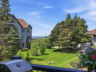Enjoy stunning lake views from this beautiful property, featuring a well-maintained lawn and mature trees.