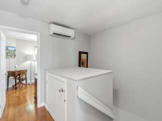 Step into this charming space featuring a sleek wall-mounted air conditioning unit for optimal comfort.