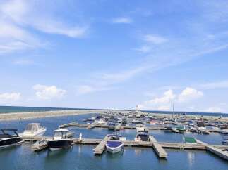 Experience the ultimate waterfront lifestyle with this stunning marina view, featuring a collection of sleek boats docked under a clear blue sky.