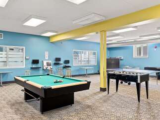 Enjoy endless entertainment in this vibrant game room, featuring a classic pool table and a thrilling foosball table.