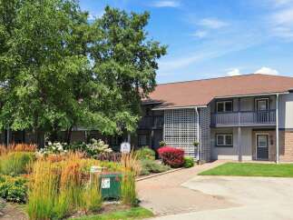 Discover comfortable living in this charming apartment complex, featuring a beautiful facade with brick accents and a welcoming entrance.