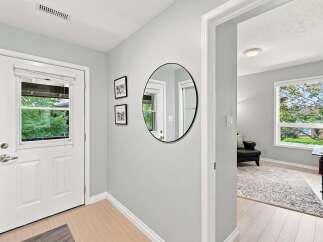 Step into this inviting entryway featuring a bright white door with a glass panel, perfect for letting in natural light.