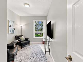 Step into this inviting living space, featuring plush black leather armchairs perfect for relaxation.