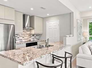 Experience modern living in this stunning kitchen featuring sleek, cream-colored cabinetry and a beautiful granite countertop.