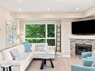 Experience modern living in this beautifully appointed living room, featuring a plush white sectional sofa perfect for relaxation.