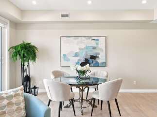 This elegant dining area features a modern glass-top dining table with four upholstered chairs, perfect for intimate gatherings.