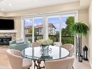 Experience elegant living with this stunning dining area, featuring a sleek glass-top table surrounded by plush chairs.