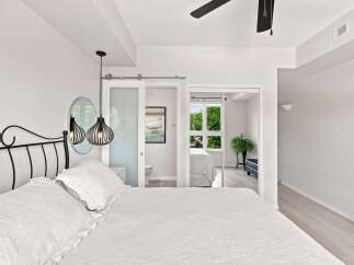 Experience modern comfort in this serene bedroom, featuring a stylish black metal bed frame and elegant pendant lighting.
