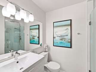Experience modern elegance in this beautifully appointed bathroom, featuring a sleek vanity with a vessel sink and chrome fixtures.