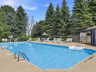 Enjoy a refreshing dip in this sparkling blue swimming pool, perfect for a hot summer day.