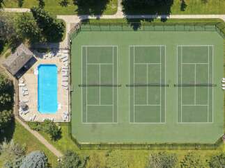 Enjoy resort-style living with this property featuring a sparkling blue swimming pool and multiple pristine tennis courts.