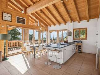 Experience luxurious mountain living in this stunning open-concept kitchen and dining area, featuring a modern island, elegant dining set, and breathtaking panoramic views.