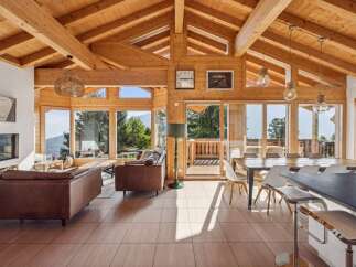 Experience luxurious mountain living in this stunning timber-framed home, boasting panoramic views through expansive windows.