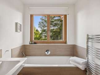 Experience tranquility in this modern bathroom featuring a deep soaking tub, perfect for unwinding after a long day.