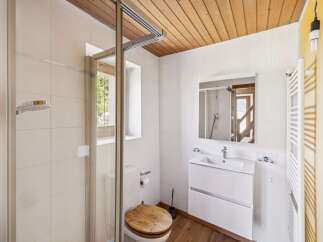 This modern bathroom features a spacious walk-in shower with a rainfall showerhead, complemented by elegant white tiled walls.