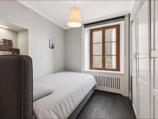 Discover this charming bedroom featuring a comfortable single bed with striped bedding, perfect for a cozy retreat.
