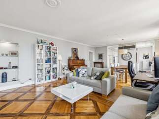 Experience elegant living in this spacious open-concept home, featuring a modern grey sofa and a striking white coffee table perfect for entertaining.