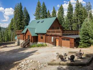 Experience rustic charm in this stunning log cabin nestled amidst towering pine trees.