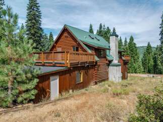 Experience rustic charm in this stunning log cabin nestled amidst towering pine trees.