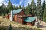Nestled amidst towering pine trees, this rustic log cabin offers a serene mountain retreat.