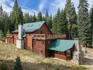 Nestled amidst towering pine trees, this rustic log cabin offers a serene mountain retreat.