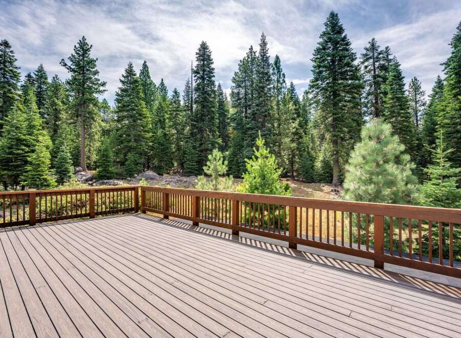Step onto this expansive wooden deck, perfect for outdoor entertaining and enjoying the serene forest views.