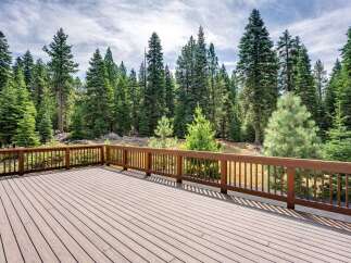 Step onto this expansive wooden deck, perfect for outdoor entertaining and enjoying the serene forest views.