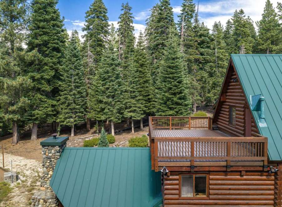 Experience the ultimate mountain retreat with this stunning log cabin nestled amidst a dense forest of towering pine trees.