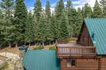 Experience the ultimate mountain retreat with this stunning log cabin nestled amidst a dense forest of towering pine trees.