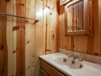 This charming bathroom features a rustic wood-paneled interior, creating a warm and inviting atmosphere.