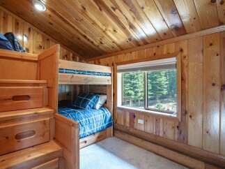 Discover cozy sleeping arrangements in this charming cabin bedroom, featuring a built-in bunk bed with convenient storage drawers.