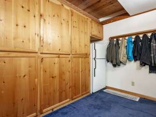 This charming space features ample storage with beautiful knotty pine cabinets, perfect for organizing your belongings.