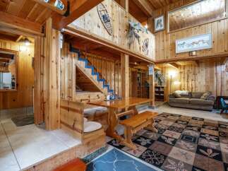 Experience rustic charm in this inviting living space featuring a cozy dining nook with a wooden table and bench seating, perfect for family meals.
