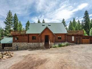 Experience rustic charm in this stunning log cabin, nestled amidst towering pine trees.