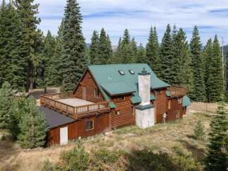 Nestled amidst towering pine trees, this rustic log cabin offers a serene mountain retreat.