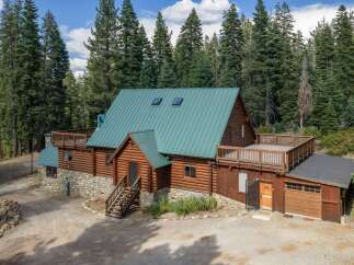 Nestled amidst towering pine trees, this charming log cabin offers a serene mountain retreat.