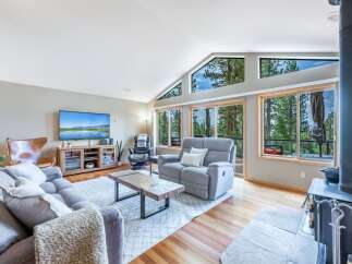 Experience breathtaking mountain views from this stunning living room, featuring a vaulted ceiling with expansive windows that flood the space with natural light.