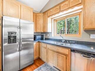 This charming kitchen boasts a full suite of stainless steel appliances, including a side-by-side refrigerator and a dishwasher.