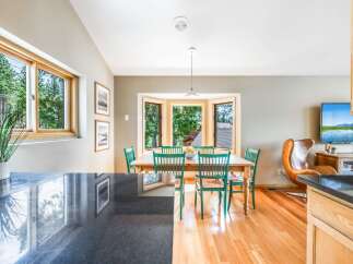 Enjoy bright and airy dining in this charming space, featuring a bay window that floods the room with natural light and offers picturesque views of the surrounding trees.