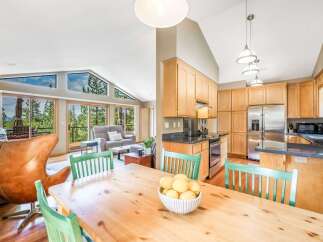 Experience breathtaking mountain views from this stunning open-concept living space, featuring a vaulted ceiling and expansive windows that flood the home with natural light.