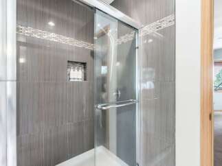 Experience luxury in this modern bathroom featuring a sleek glass-enclosed shower with elegant tilework.