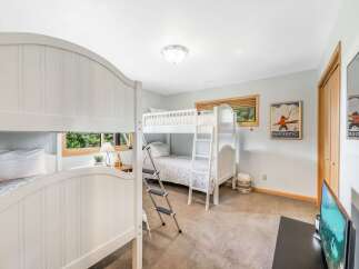 This charming bedroom features a set of white bunk beds, perfect for accommodating guests or family.