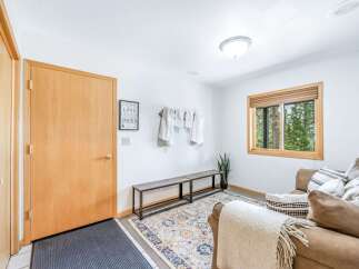 Step into a welcoming entryway featuring a warm wooden door and a comfortable seating area.