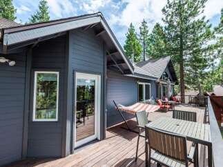 Enjoy the serene mountain lifestyle from this stunning property featuring a spacious wooden deck perfect for outdoor entertaining.