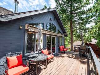Enjoy outdoor living on this spacious wooden deck, perfect for entertaining or relaxing amidst the trees.