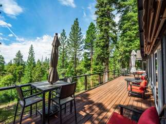 Enjoy breathtaking forest views from this expansive wooden deck, perfect for outdoor dining and relaxation.
