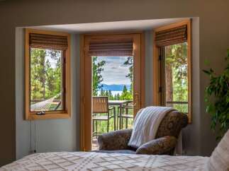 Experience breathtaking lake and mountain views from this serene bedroom retreat.