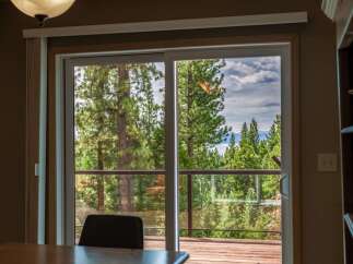 Experience breathtaking views from this stunning property, featuring a spacious deck overlooking a serene lake and lush pine forest.