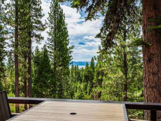 Enjoy breathtaking lake and mountain views from this stunning property, nestled amongst towering pine trees.