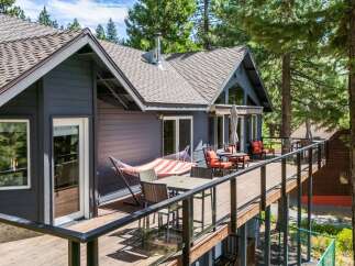 Experience outdoor living at its finest on this expansive deck, featuring a comfortable hammock and a dining set perfect for al fresco meals.